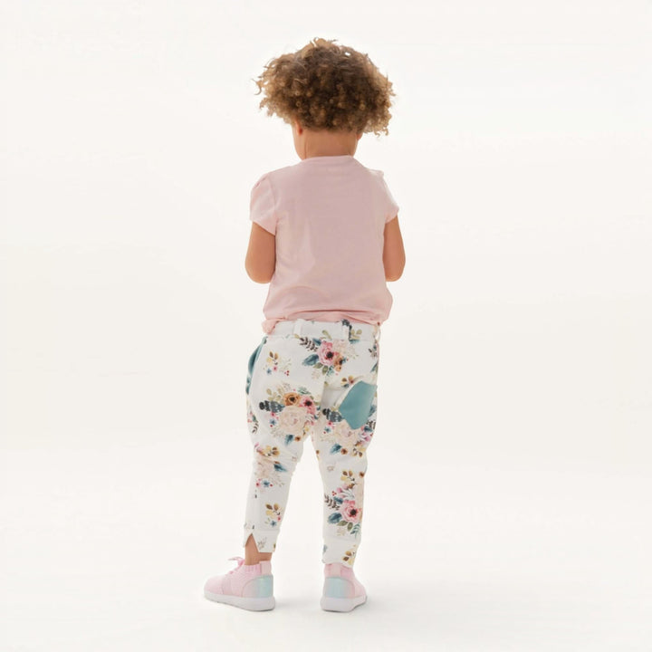 Haremshose PDF Schnittmuster DADO – Baggy Kinderhose mit Taschen 92/98–140/146, hintenansicht eines Kindes in blumigen Haremshosen.
