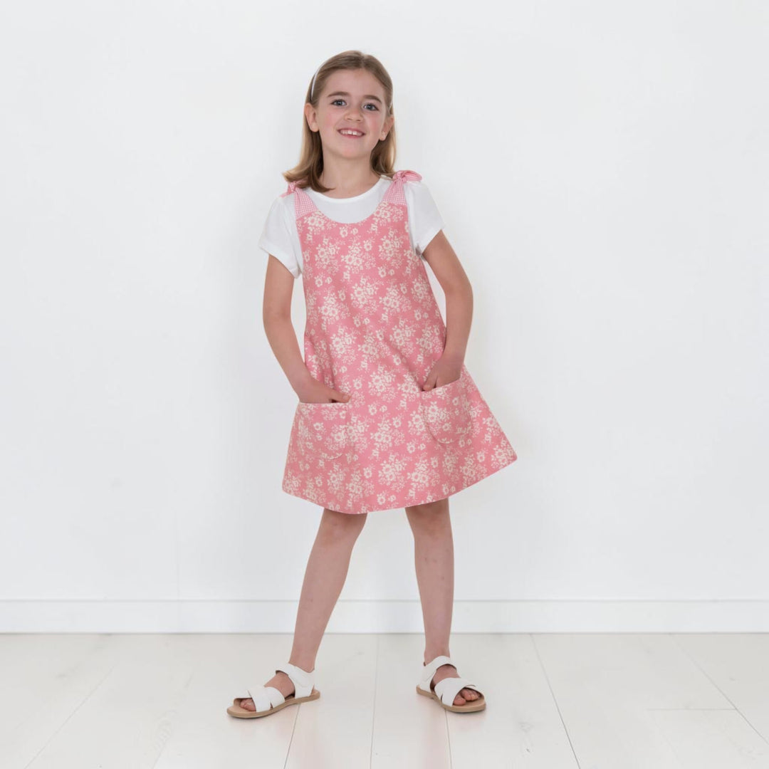 Trägerkleid PDF Schnittmuster ANTONIA – 3-in-1 Mädchenkleid 74/80–146/152, rosa, mit Blumenmuster und Taschen.