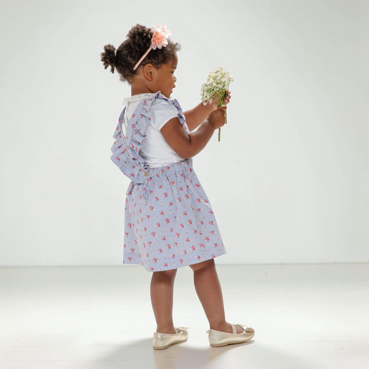 Latzkleid PDF Schnittmuster LIVIA – Rüschenkleid mit Trägern 68/74–116/122, kleines Mädchen mit Blumen im Kleid.