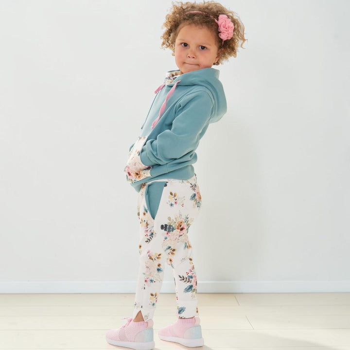 Hoodie Schnittmuster FLY DADO – Kinder Set 80/86–140/146, Hose ab 92/98: Kind mit Hoodie und floralen Jogginghosen.