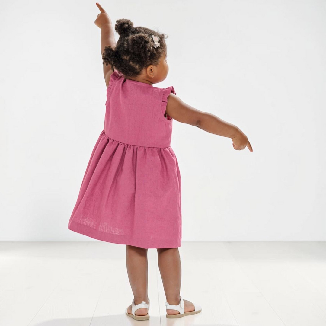Schnittmuster Sommer Mädchenkleid MIMI PDF 2 in 1 - Mädchen in einem pinken Kleid mit Rüschendetails.