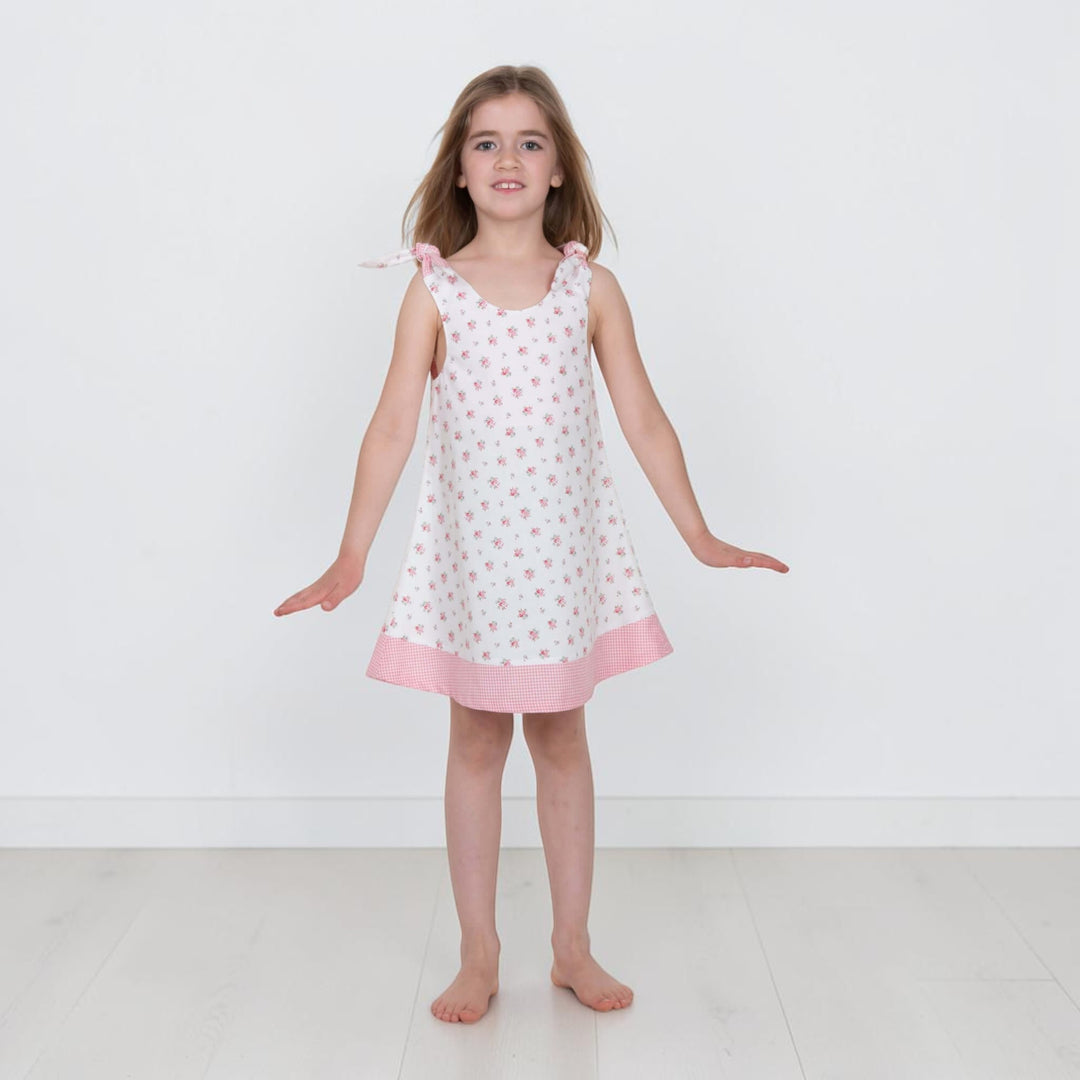 Trägerkleid PDF Schnittmuster ANTONIA – 3-in-1 Mädchenkleid 74/80–146/152, das von einem Mädchen getragen wird.