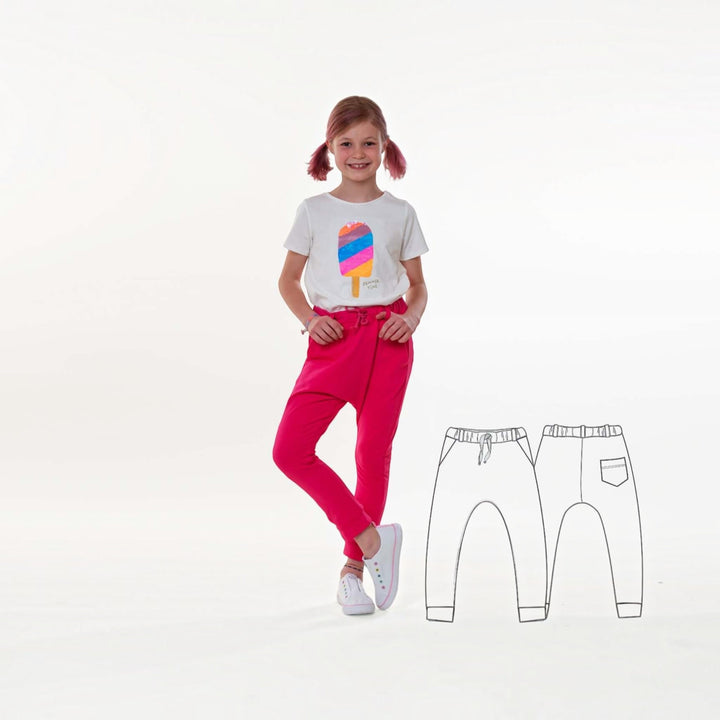 Mädchen im pinken Jogginghose mit T-Shirt und Schnittmuster Set PAULA DADO Poncho Kapuze Jogginghose im Hintergrund