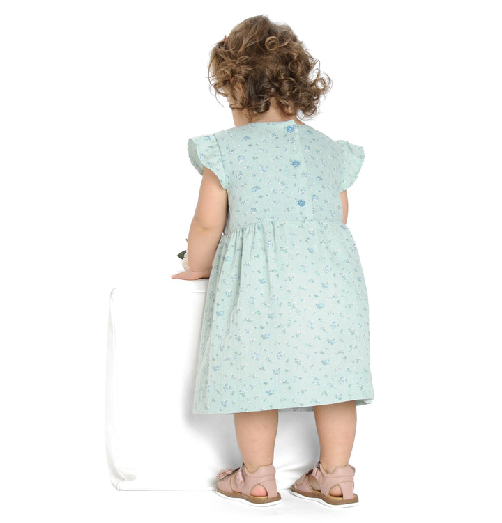 Schnittmuster Mädchenkleid ELLA – hintenansicht von Mädchen im Retro Kleid mit Volants und floralem Muster.