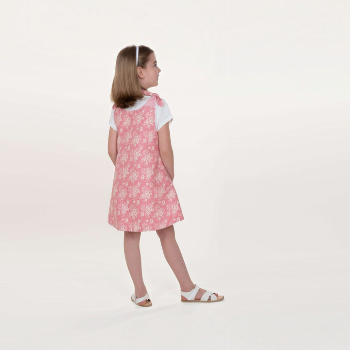 Mädchen trägt das Tunika Kleid pdf Schnittmuster JULE ANTONIA STEFFI – 3-in-1 74/80–146/152 in pinkem Blumendesign.