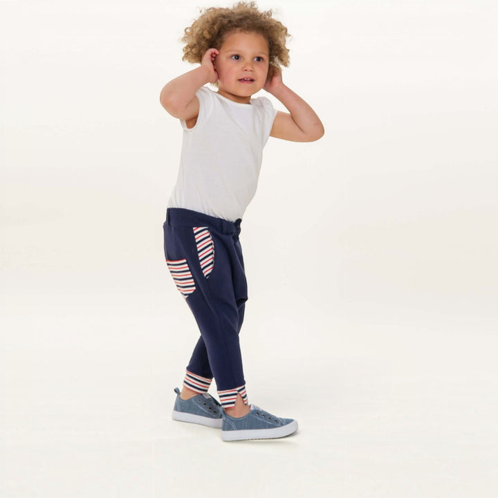 Haremshose PDF Schnittmuster DADO – Baggy Kinderhose mit Taschen 92/98–140/146 in navy worn by a child.