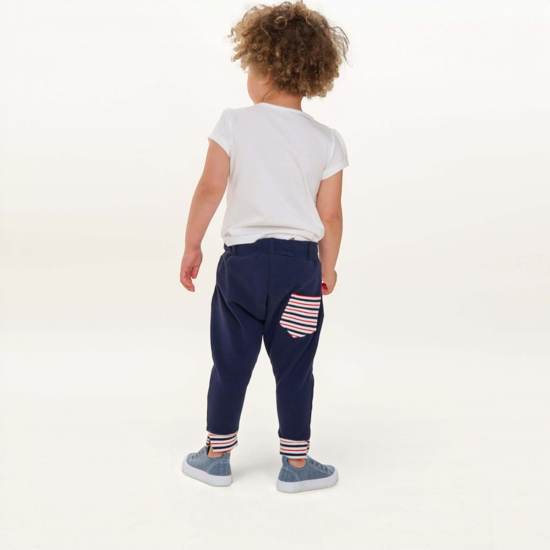 Haremshose PDF Schnittmuster DADO – Baggy Kinderhose mit Taschen 92/98–140/146, Rückansicht eines Kindes in blauer Hose mit Streifen-Pocket.