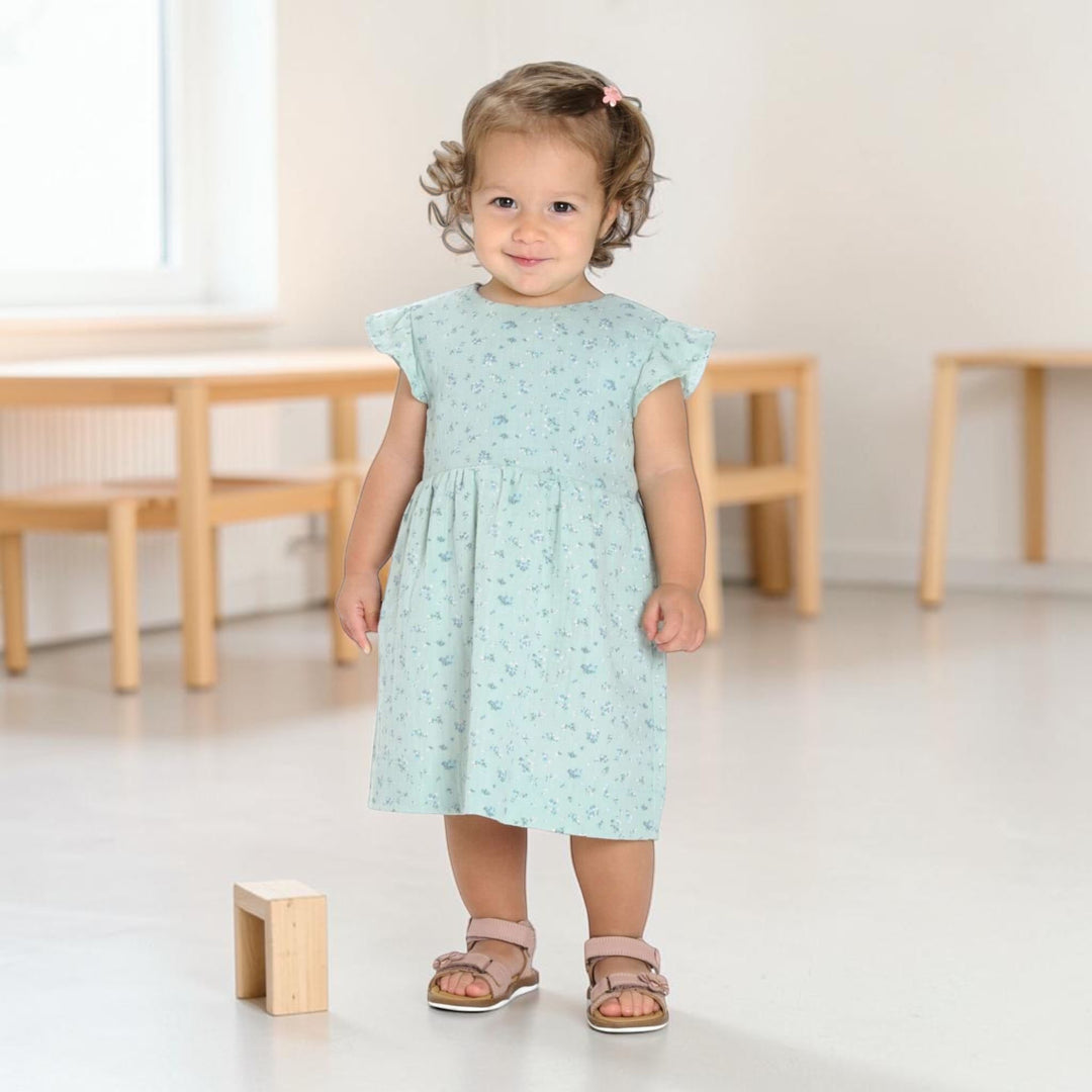 Babykleid PDF Schnittmuster ELLA – Retro Kleid mit 2 Varianten 50/56–98/104, Mädchen in blauem Kleid und Sandalen.