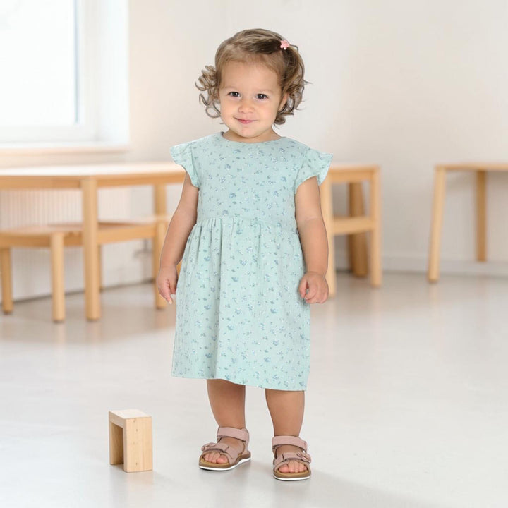 Babykleid PDF Schnittmuster ELLA – Retro Kleid mit 2 Varianten 50/56–98/104, Mädchen in blauem Kleid und Sandalen.