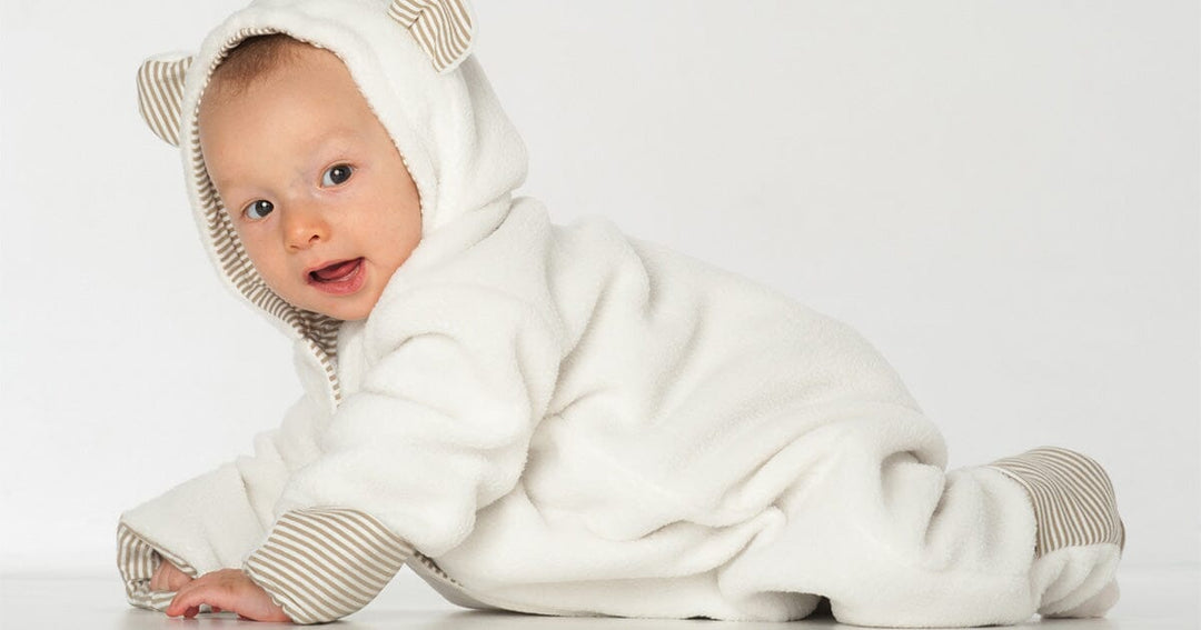 Schnittmuster Baby Jumpsuit CASSIA mit Kapuze und Ohren für Babys in Weiß.