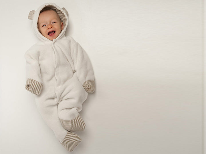 Schnittmuster Baby Jumpsuit CASSIA in weißem Hoodie-Stil für Babys, geeignet für Jungen und Mädchen.