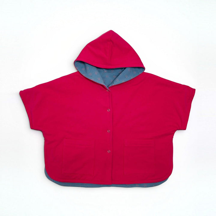 Schnittmuster Set PAULA DADO Poncho in leuchtendem Rot mit Kapuze und Taschen, ideal für Kinderoutfits.