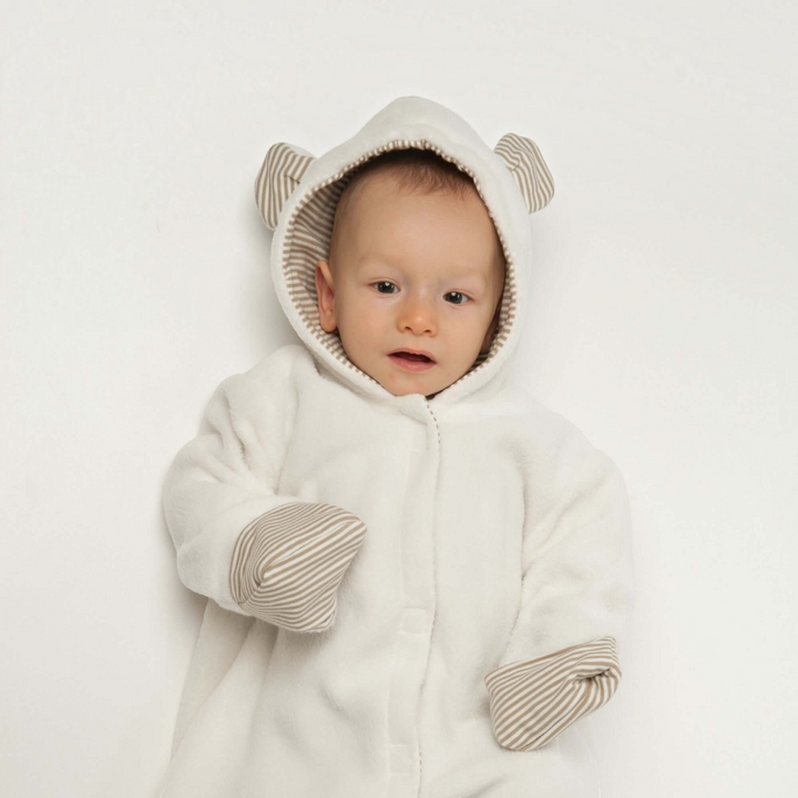 Patternforkids Schnittmuster CASSIA: Baby-Kapuzenstrampler aus weißem Fleece mit gestreiften Details und Bärenohren.