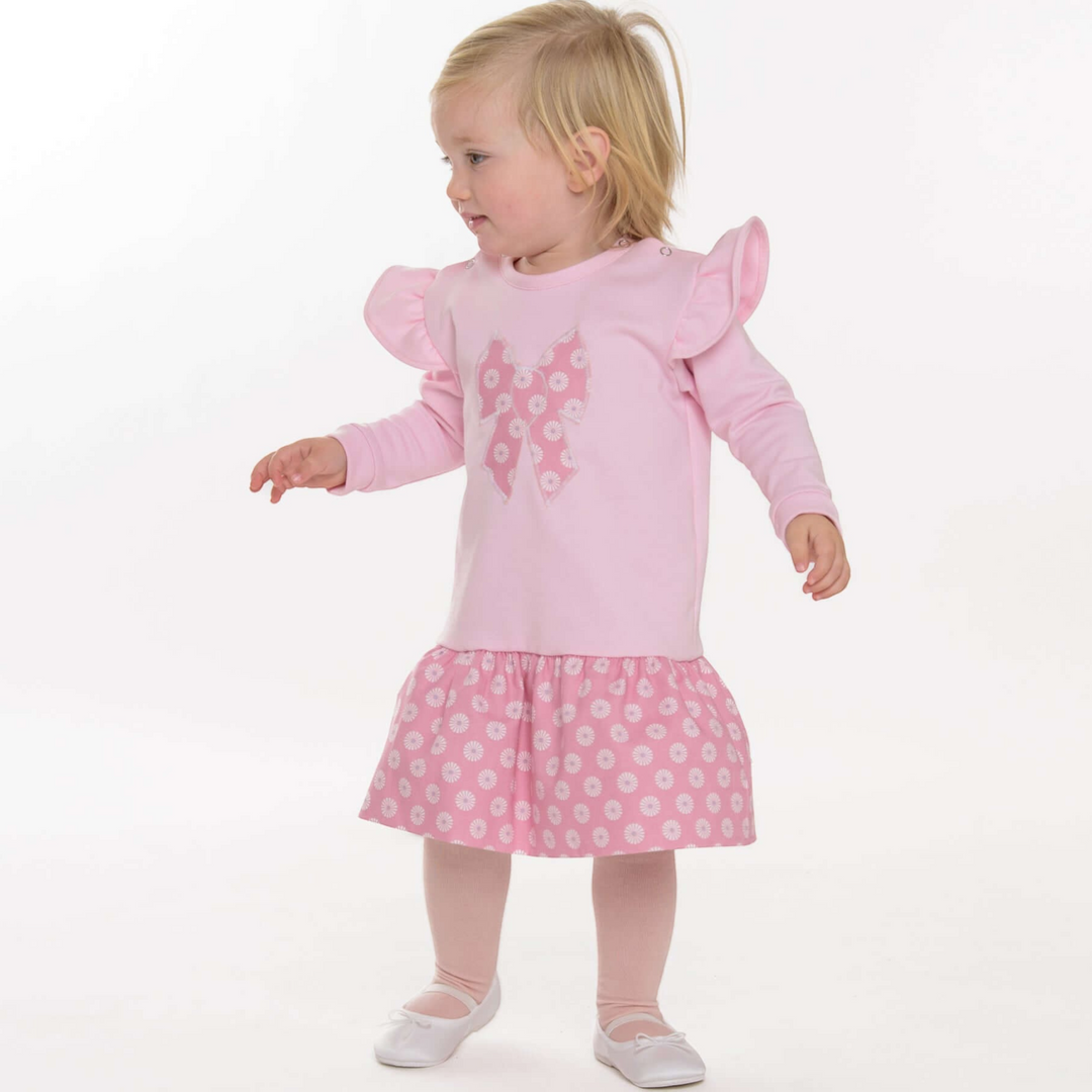 Kleinkind trägt ein Patternforkids Kleid mit Rüschenärmeln, Schleifen-Applikation und geblümtem Rock in Rosa