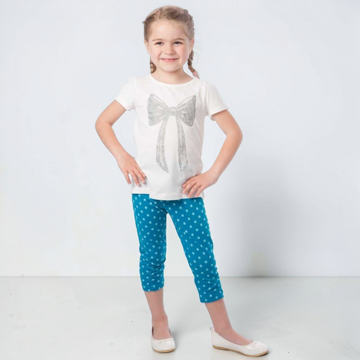 Patternforkids Baby Leggings BIBI in Blau mit weißen Punkten, getragen von einem Mädchen mit weißem Schleifen-Shirt