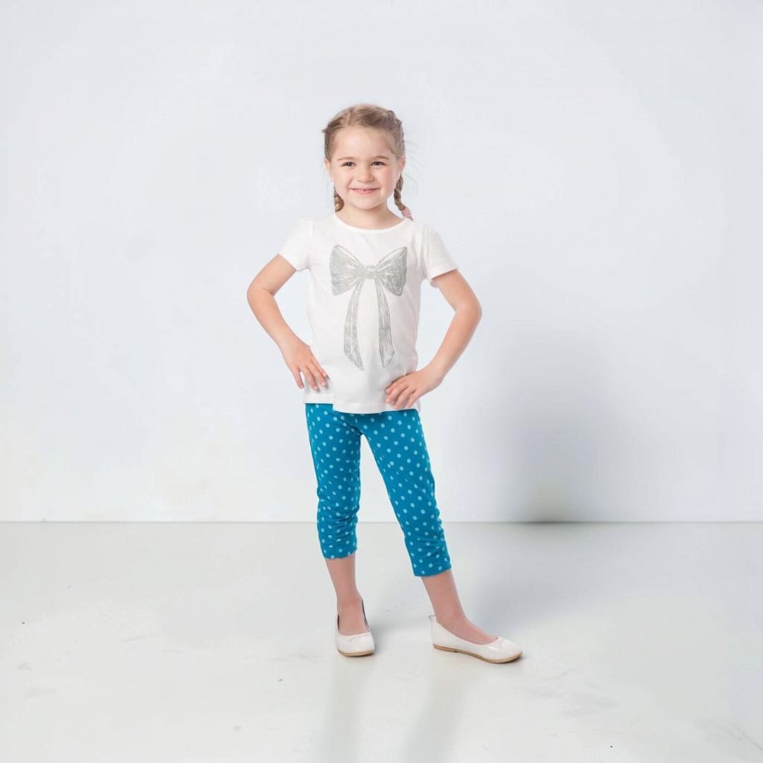 Patternforkids Baby Leggings BIBI Schnittmuster, blaue gepunktete Jersey-Leggings an einem lächelnden Mädchen