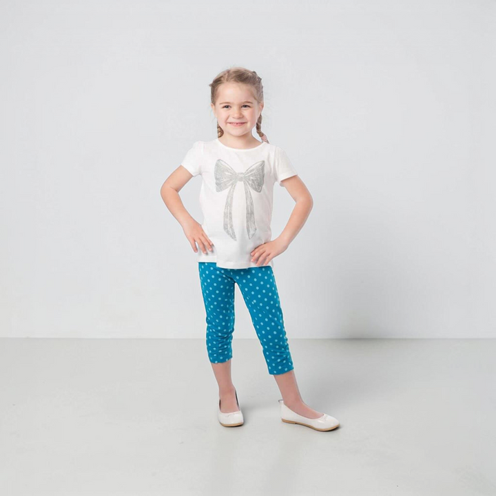 Patternforkids Baby Leggings BIBI Schnittmuster, blaue Leggings mit weißen Punkten an einem lächelnden Mädchen