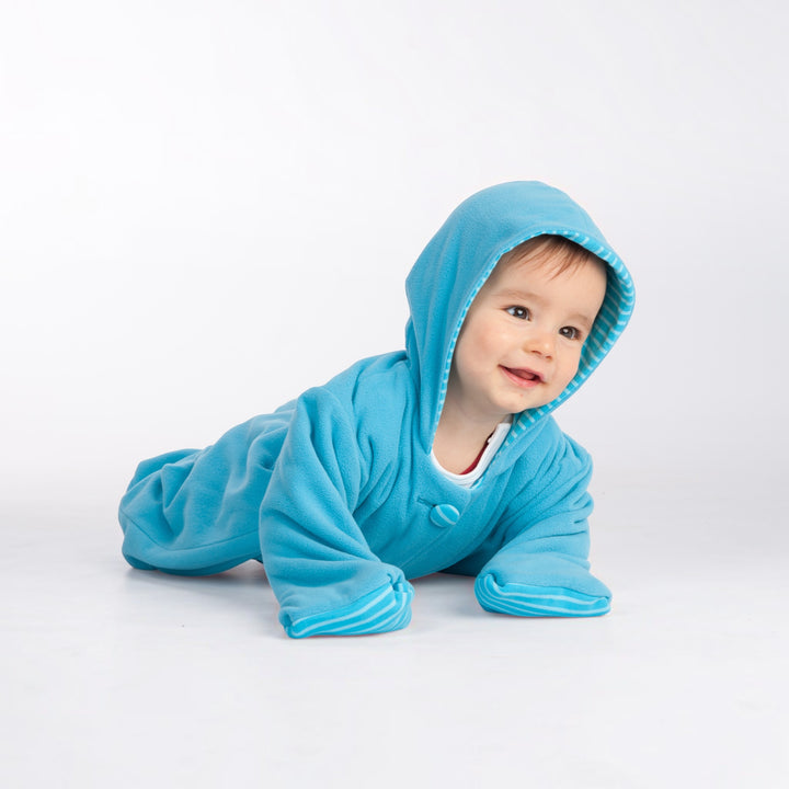 Patternforkids Baby Overall Dorian aus blauem Fleece mit Kapuze und gestreiftem Innenfutter beim Krabbeln