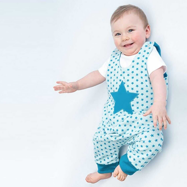 Patternforkids Baby-Overall Alberto mit blauem Sternenmuster und Bündchen, getragen von einem lächelnden Baby