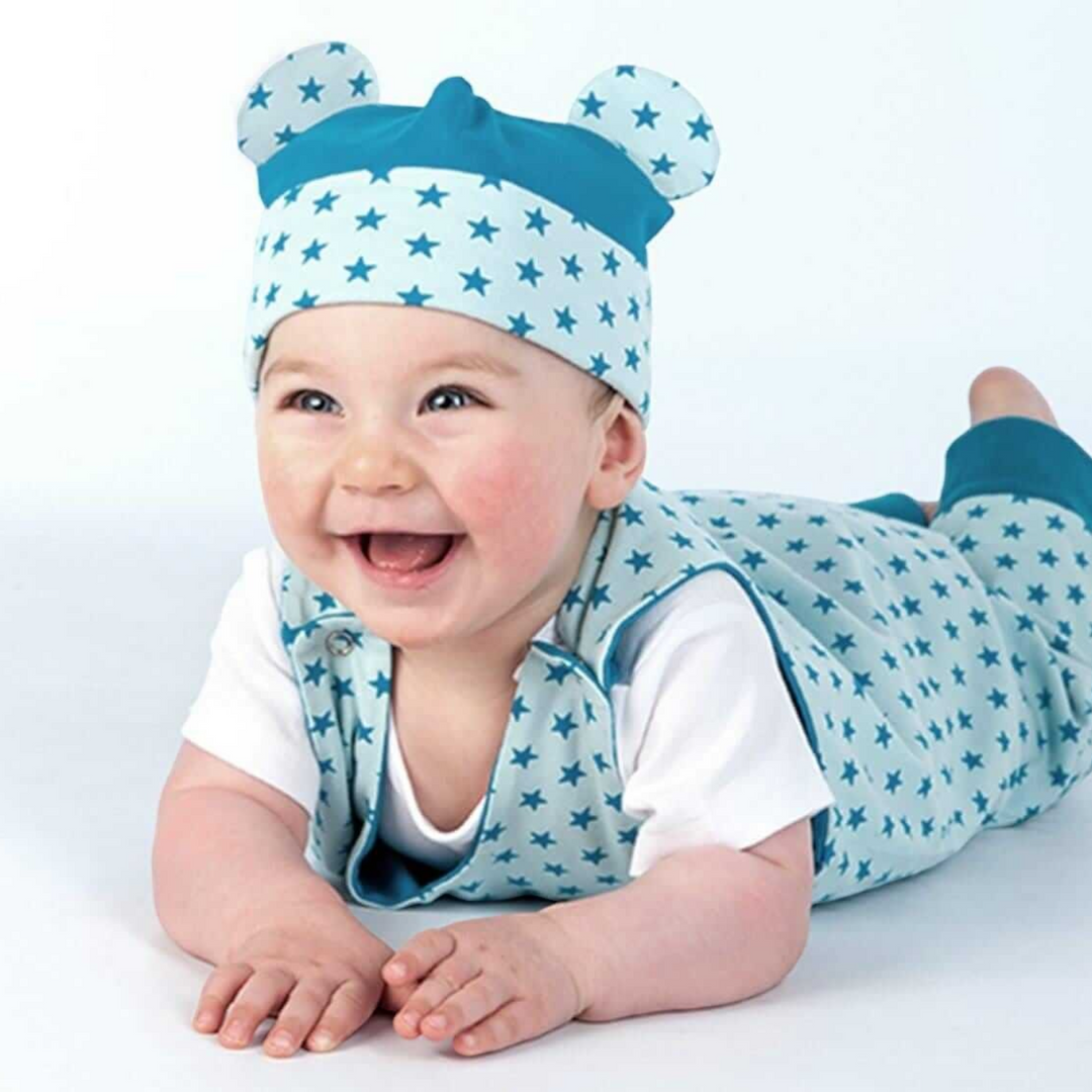 Patternforkids Baby-Set Schnittmuster mit Overall, Jacke und Mütze mit blauem Sternenmuster an einem lachenden Baby