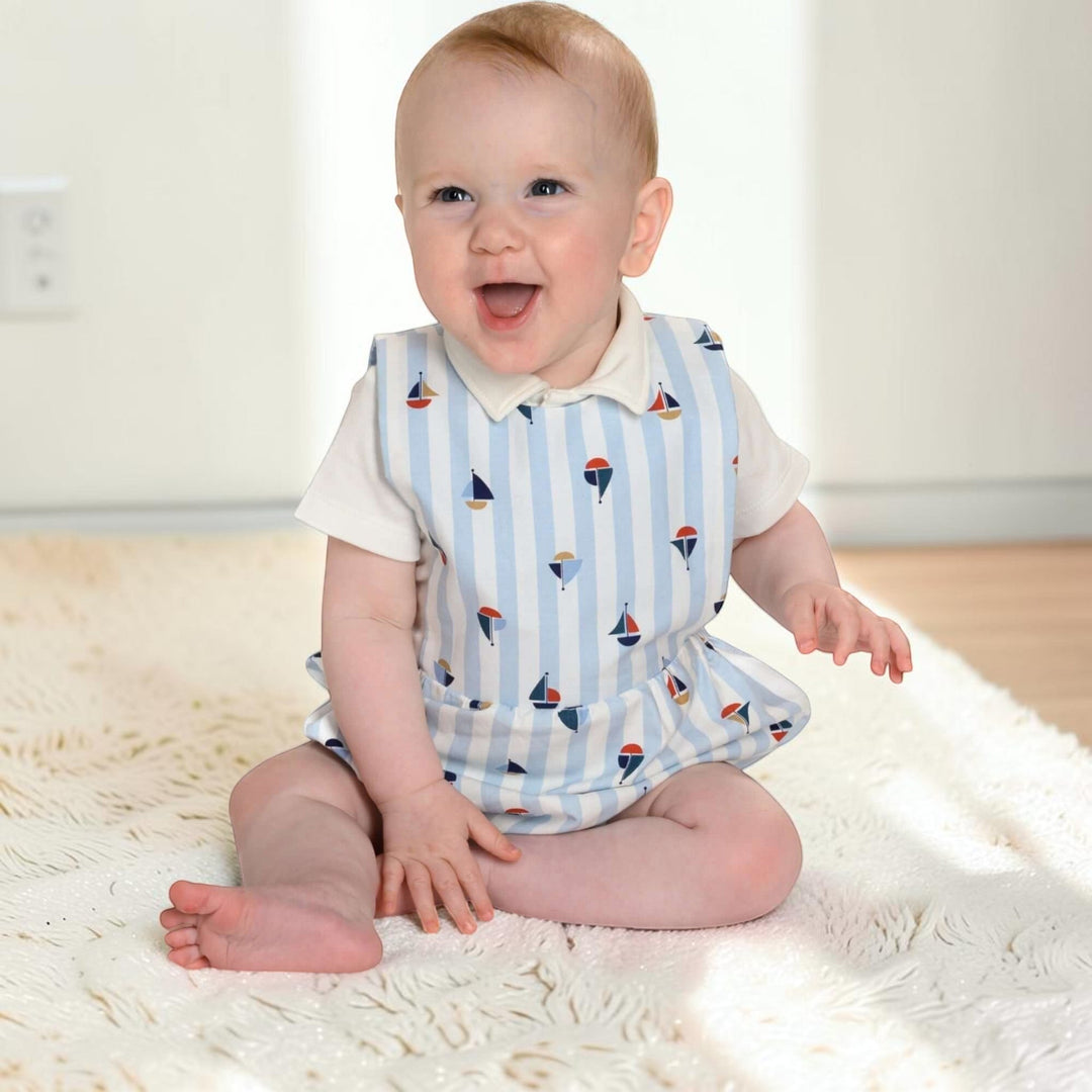 Patternforkids Baby Strampler MARCO als gestreifter Bloomer mit Segelboot-Muster, getragen von einem lachenden Baby