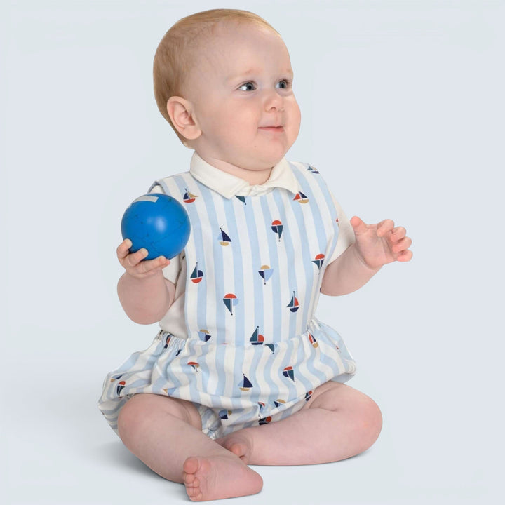 Patternforkids Baby Strampler MARCO als gestreifter Bloomer mit Segelboot-Muster, getragen von einem Baby.