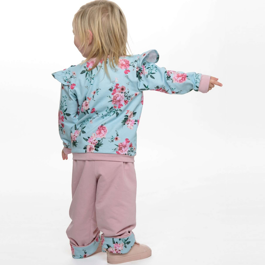 Patternforkids Baby Sweatshirt SOPHIE mit Rüschen und Blumenmuster, kombiniert mit einer rosa Hose in Rückansicht.