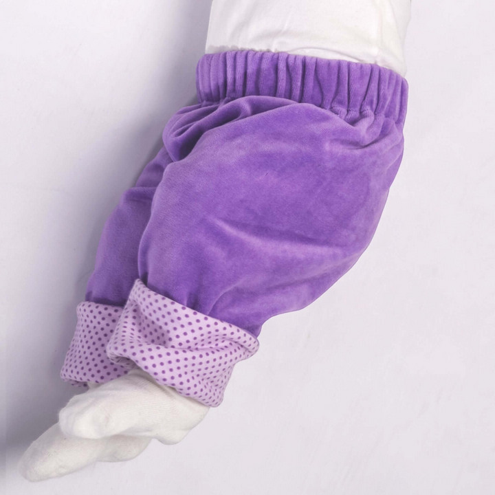 Patternforkids Baby Wendehose FIORETTO aus lila Velours mit gepunkteten Umschlagbündchen an einer Babyfigur