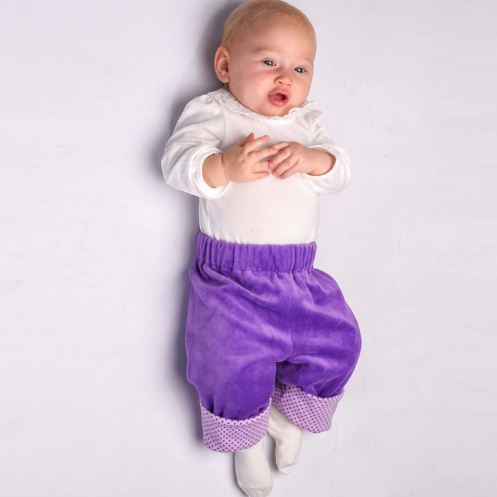Patternforkids Baby Wendehose FIORETTO aus lila Velours mit gepunkteten Umschlagbündchen an einem Baby