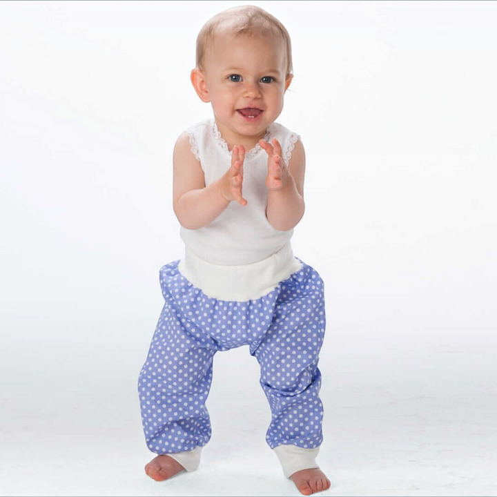 Patternforkids Babyhose BREK als blaue Pumphose mit weißen Punkten und bequemen Bündchen an einem lachenden Kleinkind