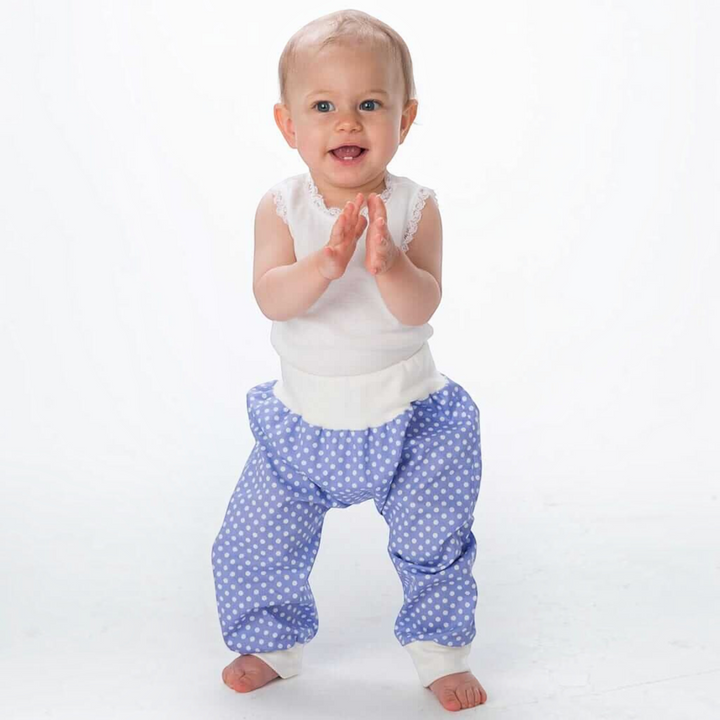 Patternforkids Babyhose BREK als blaue Pumphose mit weißen Punkten und bequemen Bündchen an einem lachenden Kleinkind