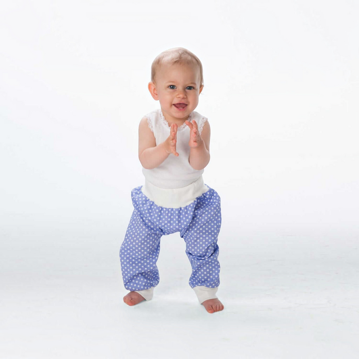 Patternforkids Babyhose BREK als blaue Pumphose mit weißen Punkten und bequemen Bündchen an einem lachenden Baby
