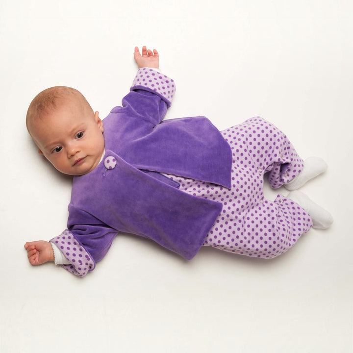 Patternforkids Babyjacke FILIPPA aus lila Nicki mit Knöpfen und gepunktetem Innenfutter an einem Baby