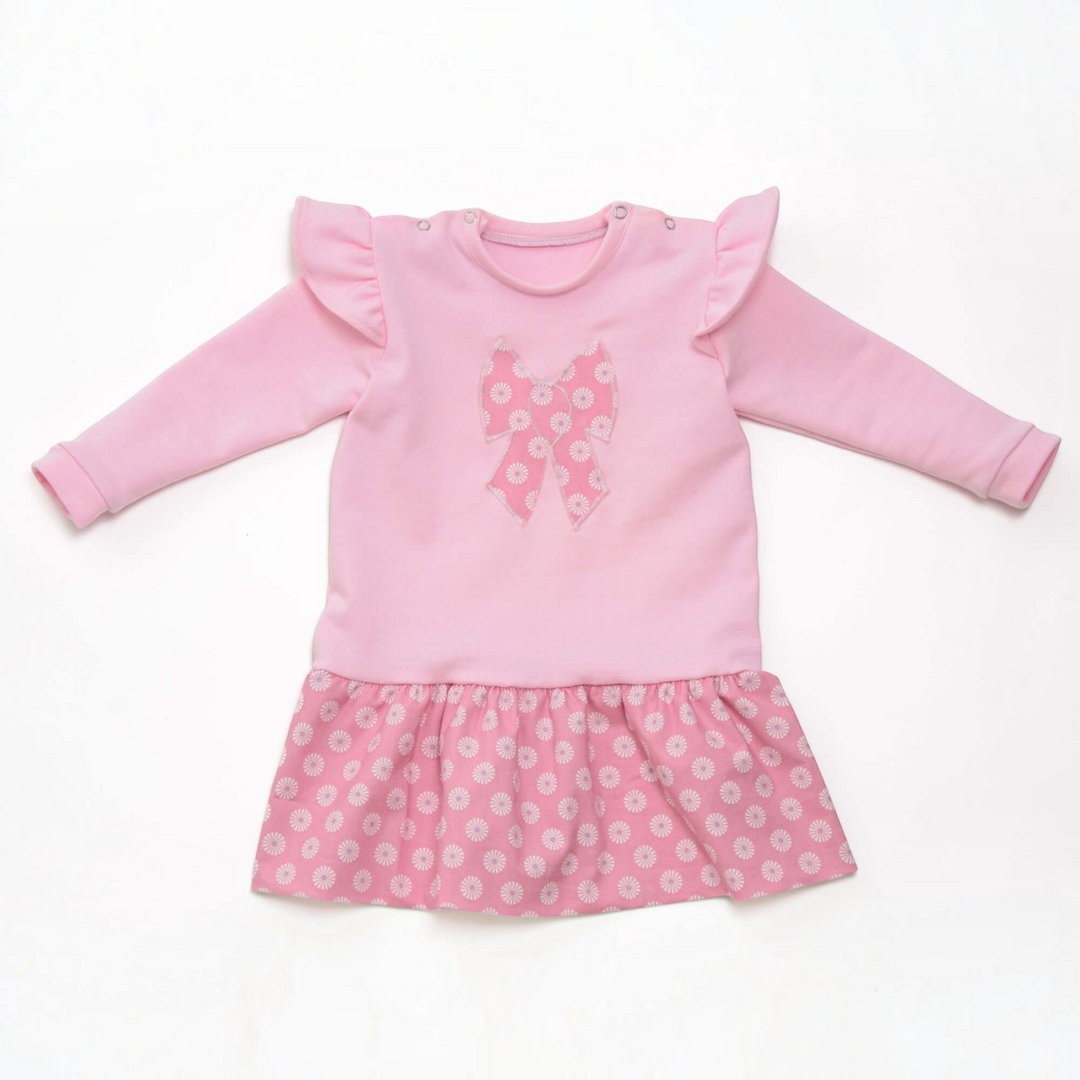 Patternforkids Babykleid Sophie in Rosa mit Rüschen an den Schultern und gemustertem Rockteil mit Schleifen-Applikation