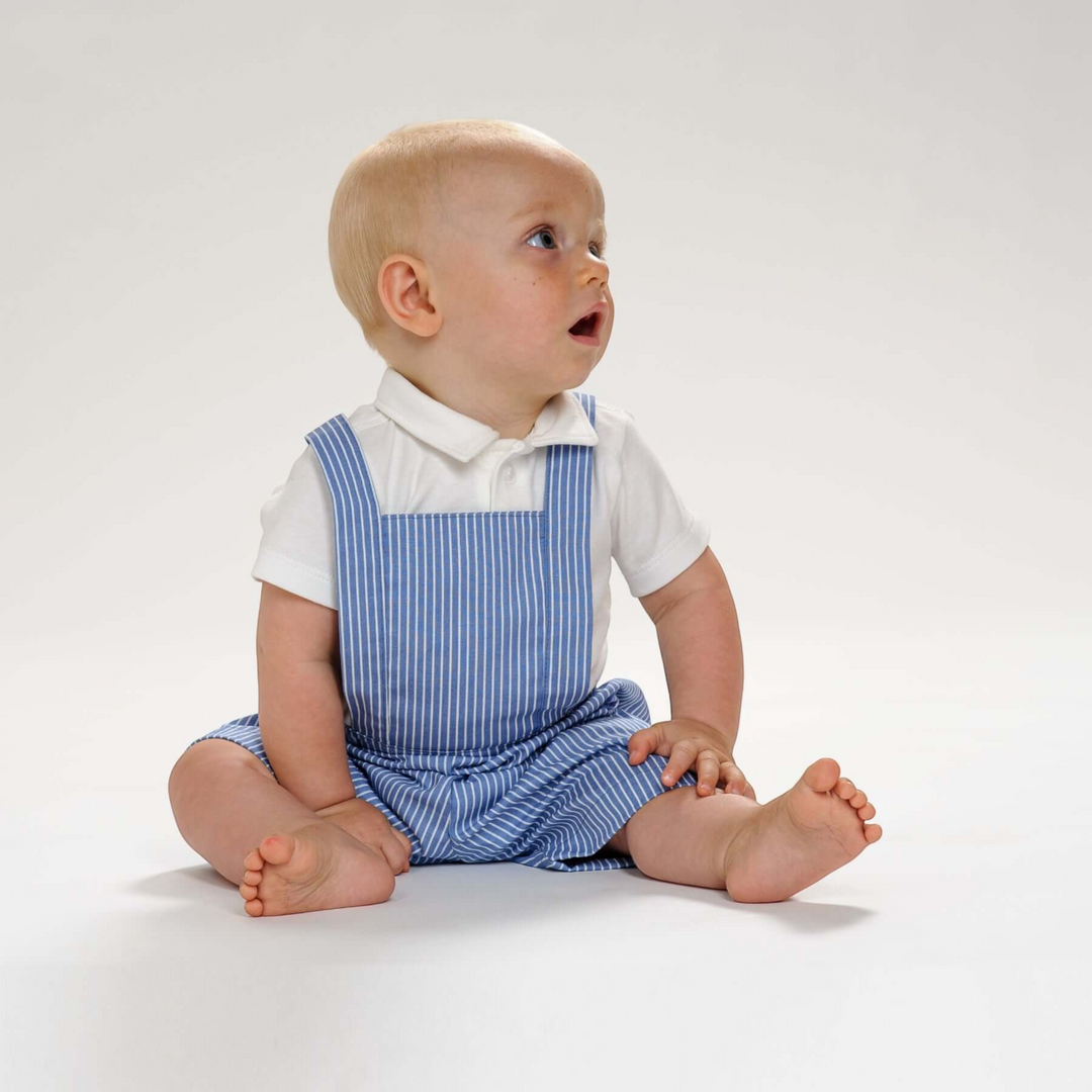 Kleinkind trägt eine blau-weiß gestreifte Latzhose von Patternforkids aus Baumwolle mit kurzem Bein