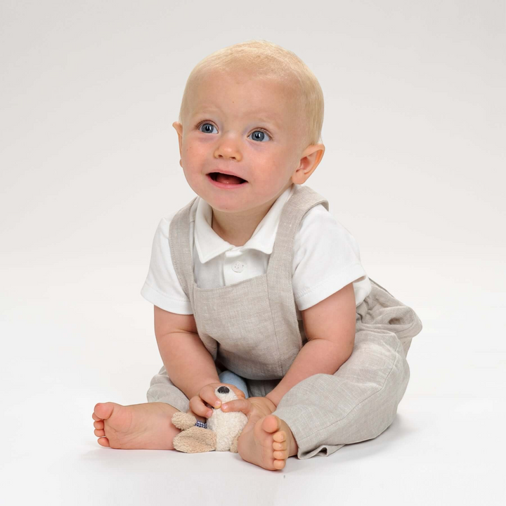 Patternforkids Kleinkind Latzhose MAX aus beigem Leinenstoff getragen von einem Baby auf weißem Hintergrund