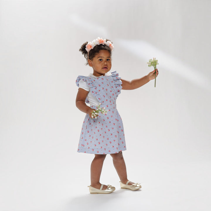Latzkleid PDF Schnittmuster LIVIA – Rüschenkleid mit Trägern 68/74–116/122, babygirl in floral dress holding flowers.