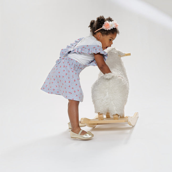 Latzkleid PDF Schnittmuster LIVIA – Rüschenkleid mit Trägern 68/74–116/122, Mädchen in Rüschenkleid spielt mit Spielzeug.