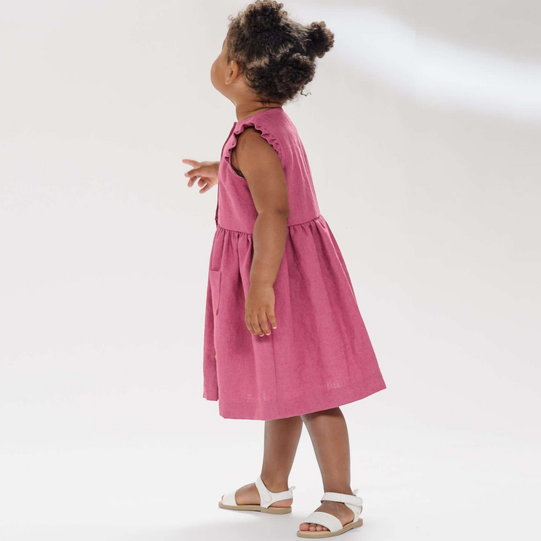 Patternforkids Mädchenkleid MIMI in Altrosa mit Rüschenärmeln und aufgesetzten Taschen an einem Kind