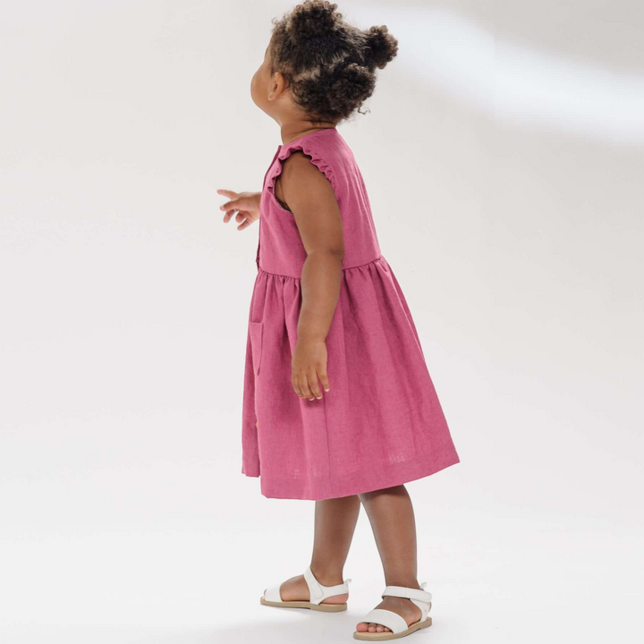 Patternforkids Mädchenkleid MIMI in Altrosa mit Rüschenärmeln und aufgesetzten Taschen an einem Kind