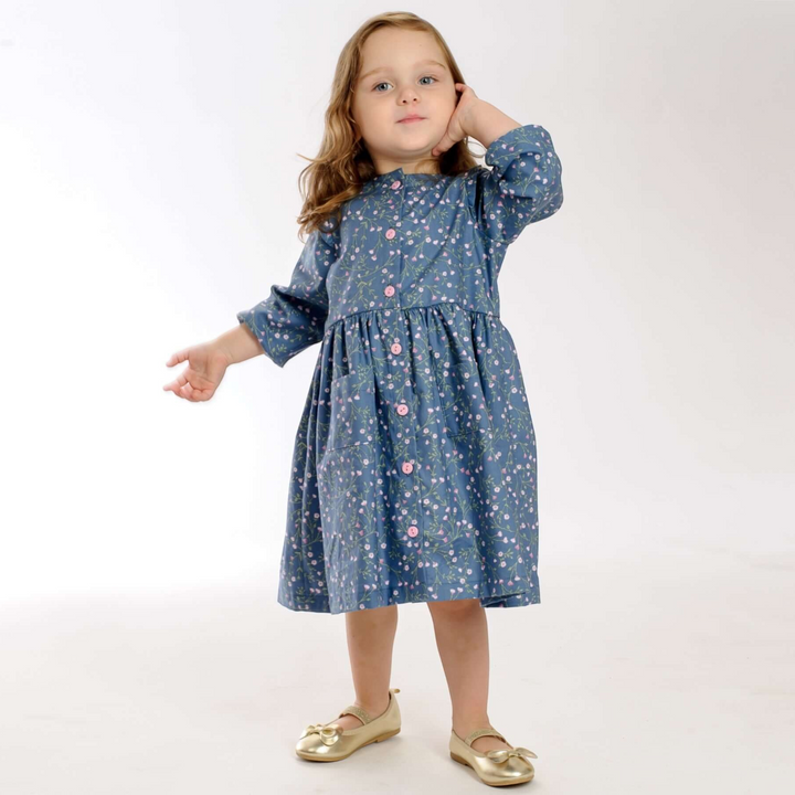 Patternforkids Mädchenkleid MIMI mit Blumenmuster, Knopfleiste und Taschen, getragen von einem kleinen Mädchen