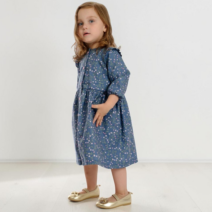 Kleines Mädchen trägt ein blaues Langarmkleid mit Blumenmuster aus dem Patternforkids Schnittmuster MIMI