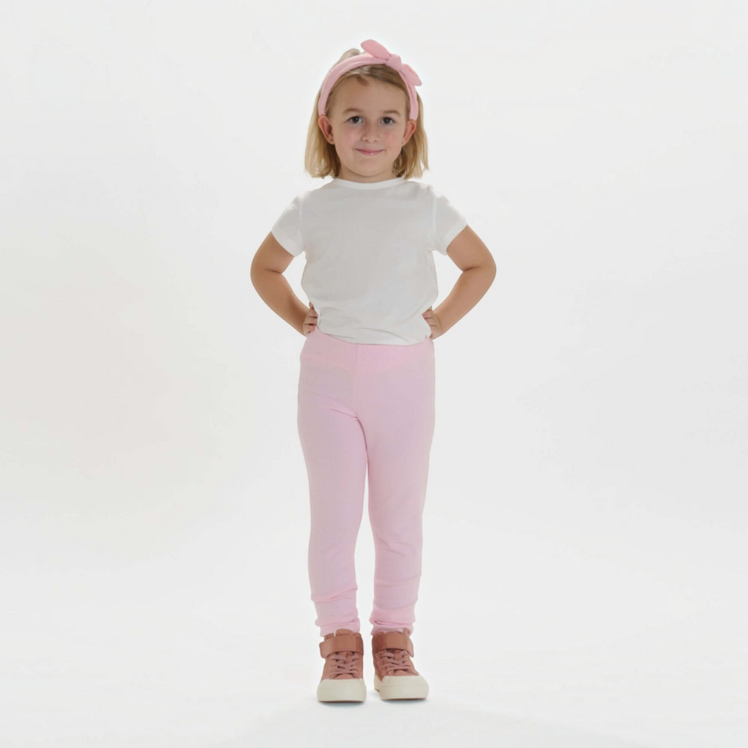 Patternforkids Schnittmuster ENNA: Mädchen trägt eine hellrosa Leggings aus Jersey mit elastischem Bund.