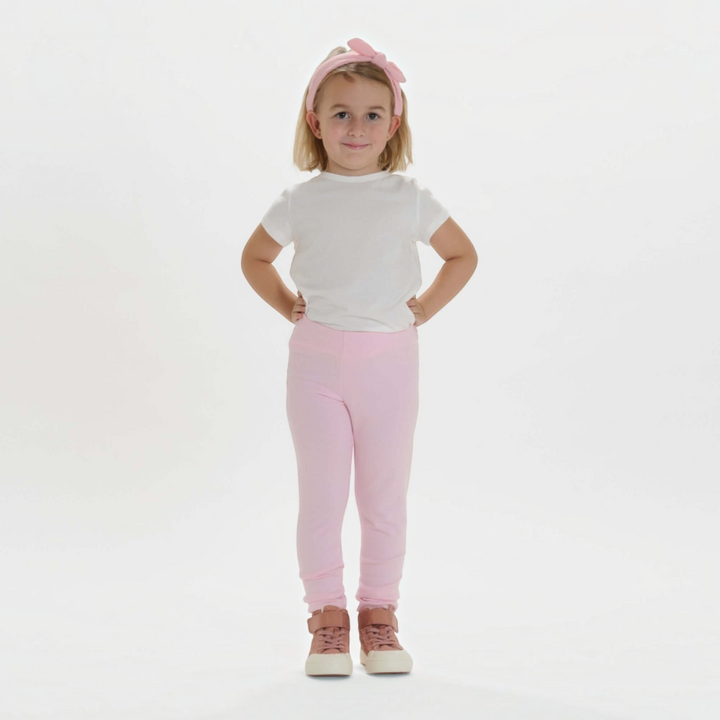 Patternforkids Schnittmuster ENNA: Mädchen trägt eine hellrosa Leggings aus Jersey mit elastischem Bund.