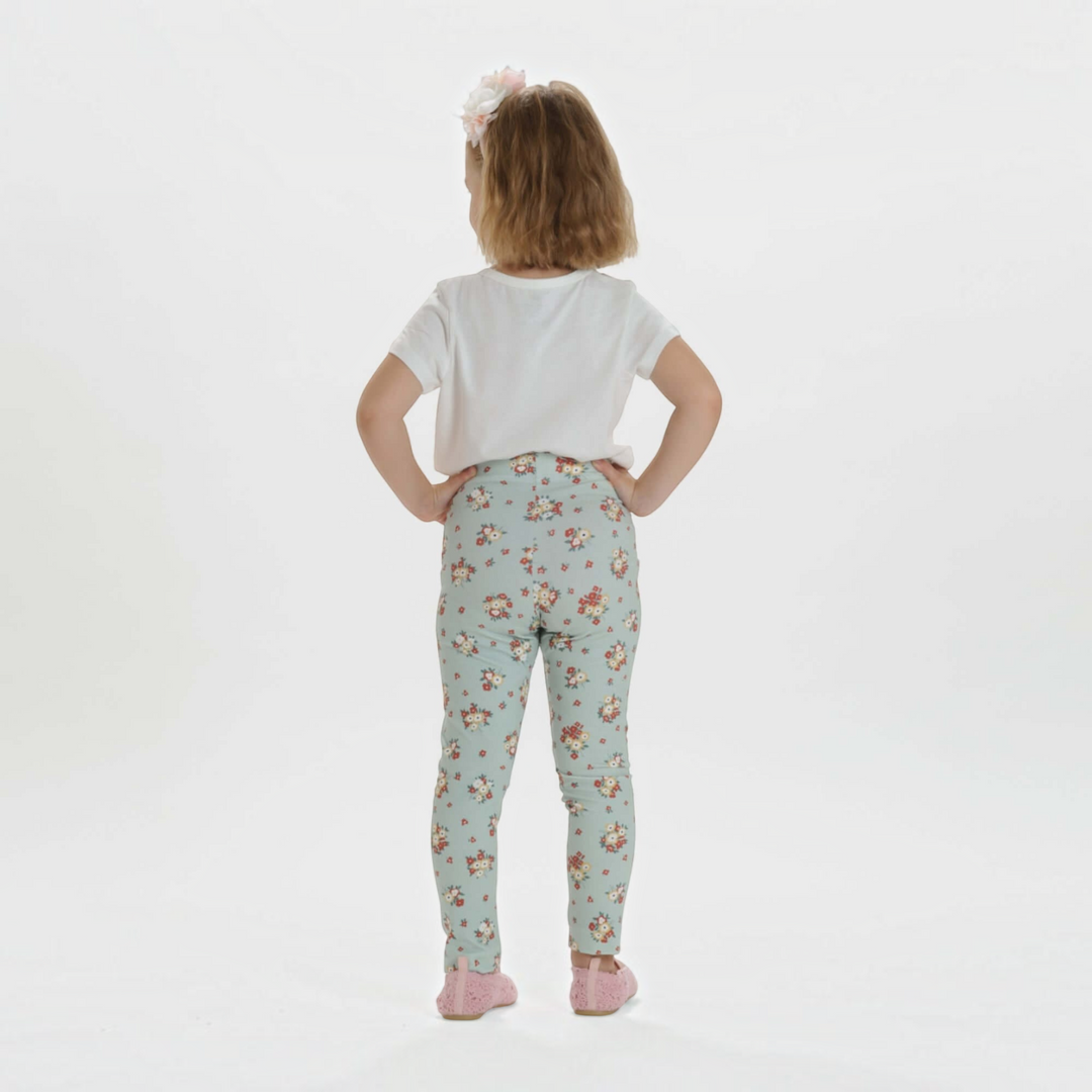 Patternforkids Schnittmuster ENNA: Kind trägt schmale Leggings mit Blumenmuster aus Jersey in hellblau