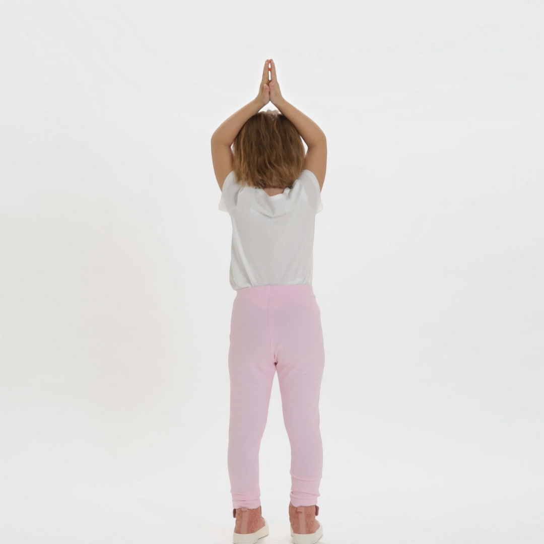Patternforkids Schnittmuster ENNA: Kind trägt eine hellrosa Leggings aus Jersey in schmaler Passform von hinten