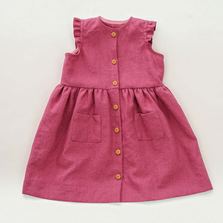 Patternforkids Schnittmuster MIMI: Ärmelloses Mädchenkleid in Altrosa mit Knopfleiste, Volants und aufgesetzten Taschen.