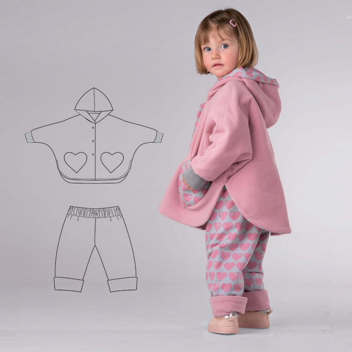 Patternforkids Schnittmuster Set MARA FIOCCO: Kind trägt rosa Poncho mit Herz-Tasche und gemusterte Wendehose.