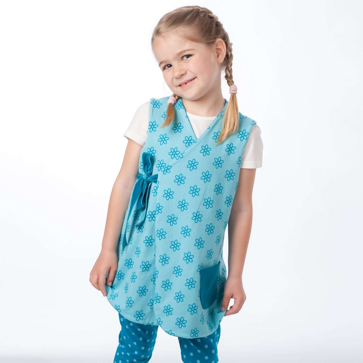 Patternforkids Schnittmuster LENA ENNA: Mädchen trägt eine hellblaue Blumen-Tunika und gepunktete Leggings.