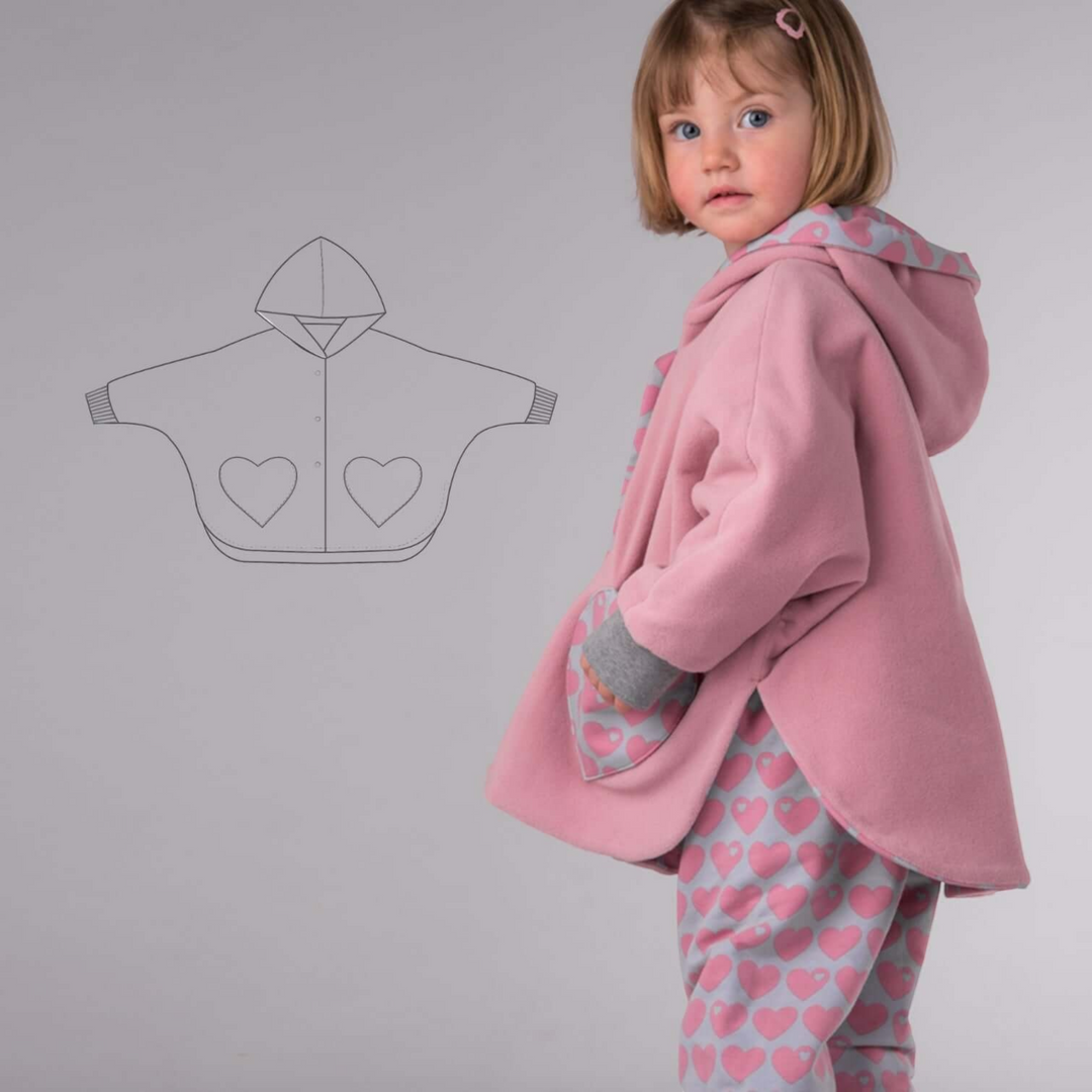 Patternforkids Wendeponcho MARA Schnittmuster mit Kapuze und Herztaschen an einem Kind in Rosa
